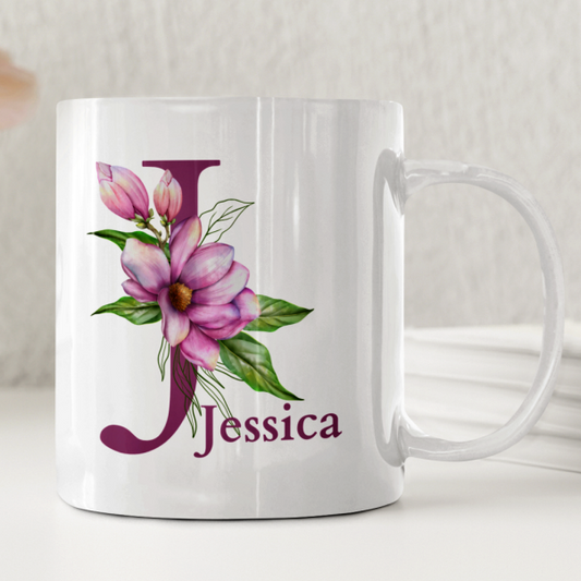 Vit keramikmugg med en stor ljuslila bokstav prydd av en elegant orkidé och personligt namn.